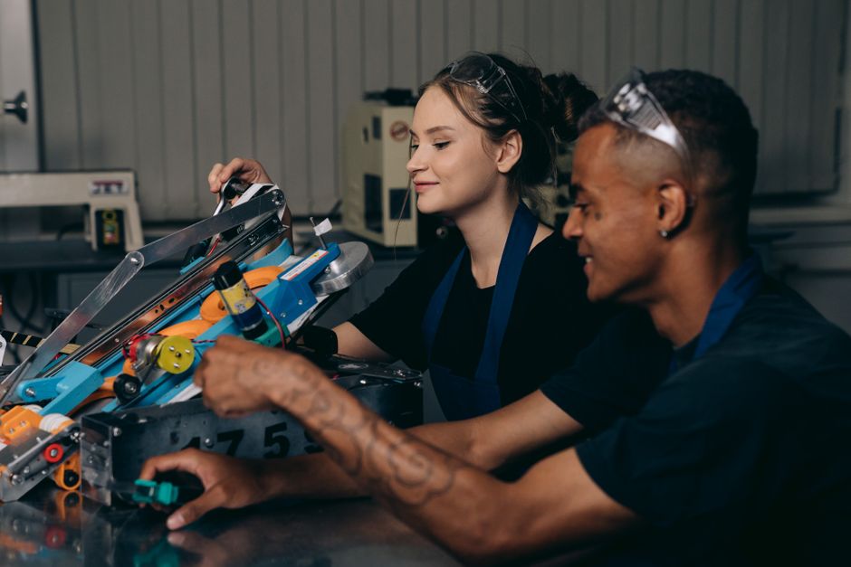 Two engineers working on a robotics project, showcasing teamwork and innovation.
